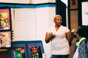 Woman with short hair and white shirt speaking in a classroom