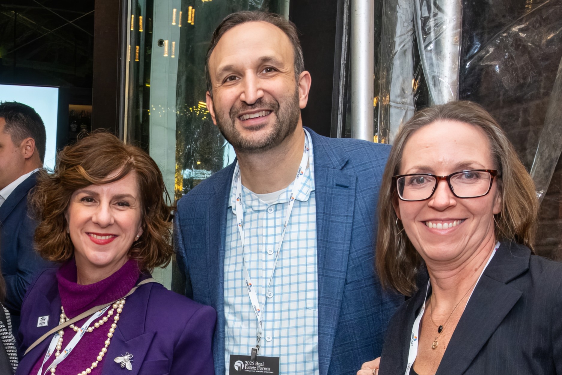 Three people in business attire smiling
