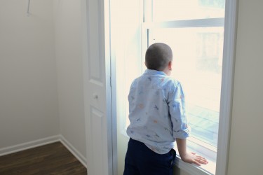 Boy looking out window in new Habitat home