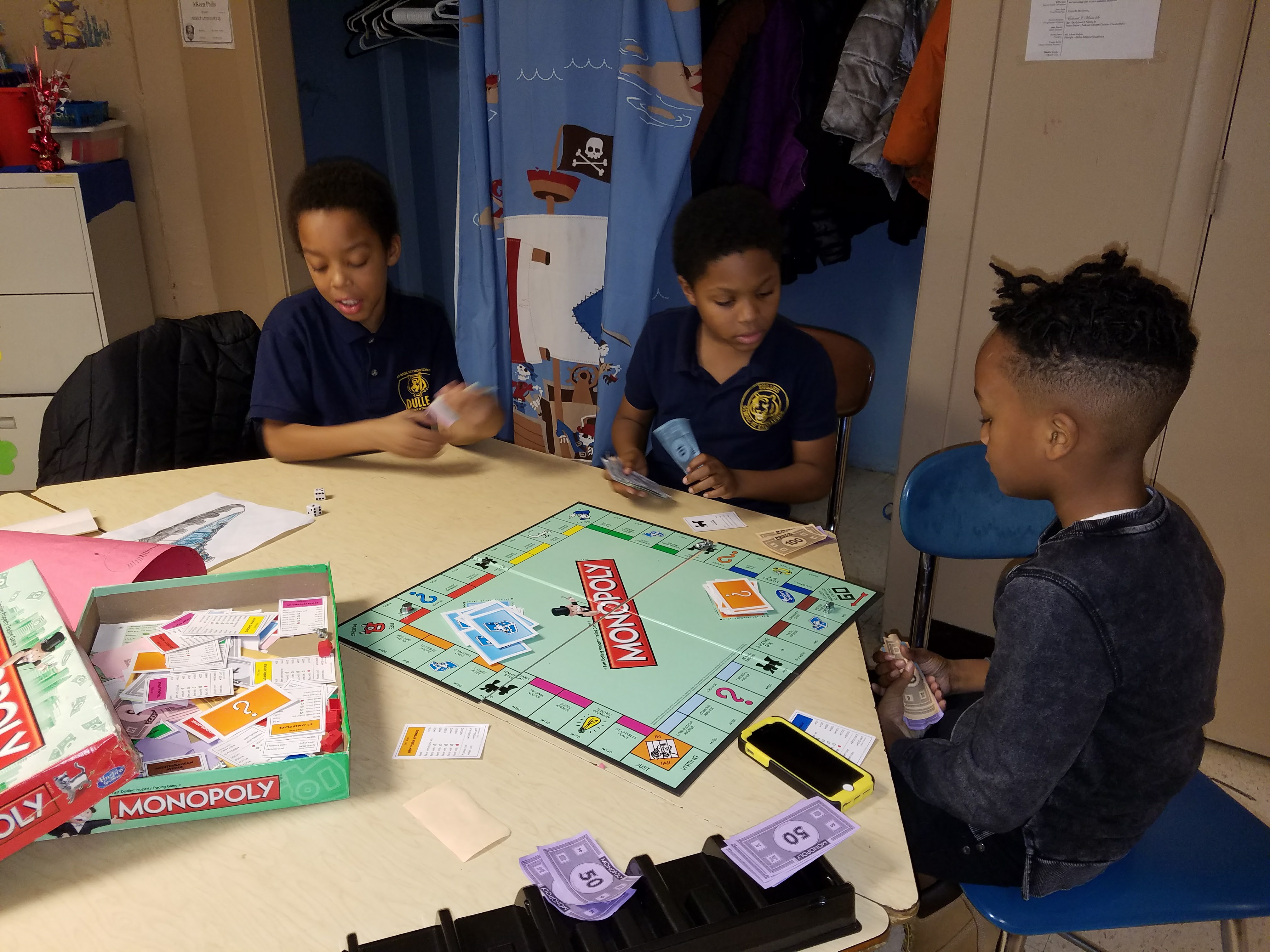 Three boys playing Monopoly