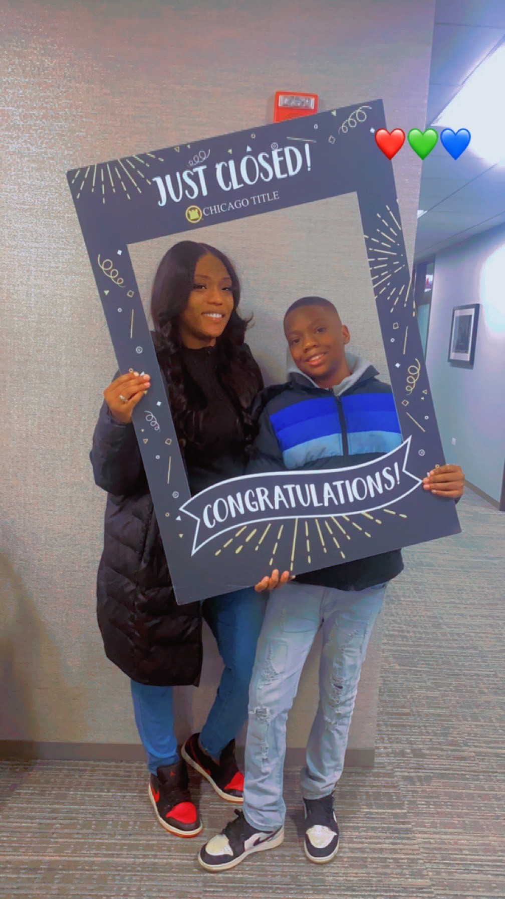 Mother and son holding a prop frame, "Just Closed!"