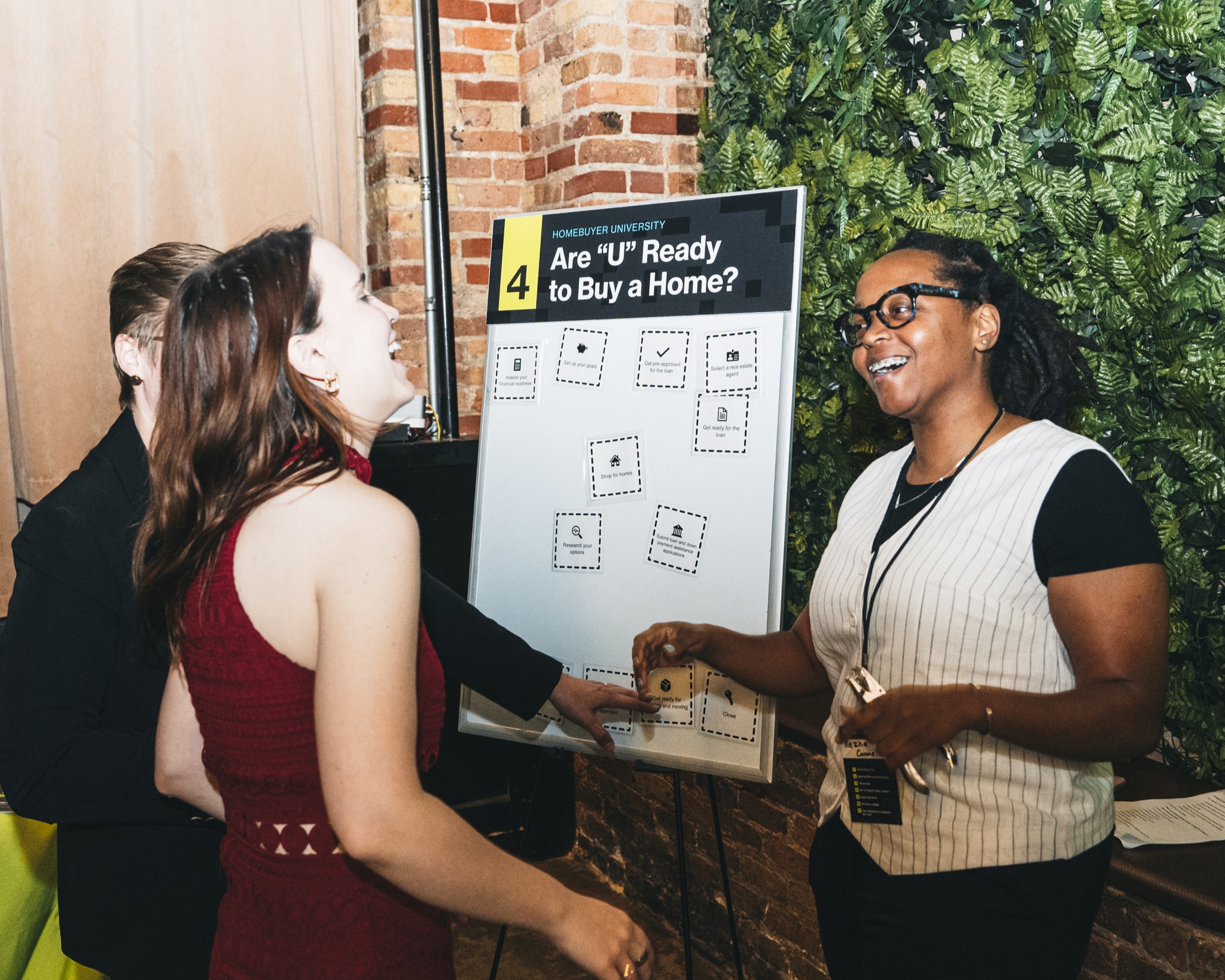 Women laughing while pointing at an activity board